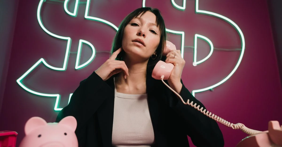 Femme confiante sur un téléphone rose avec des enseignes néon en forme de dollar. Thème finance.