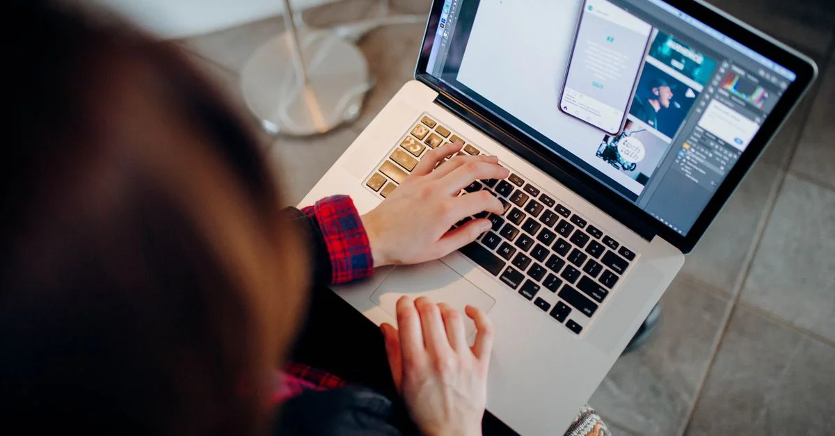 Gros plan d'une personne travaillant sur un ordinateur portable avec un logiciel de design graphique.