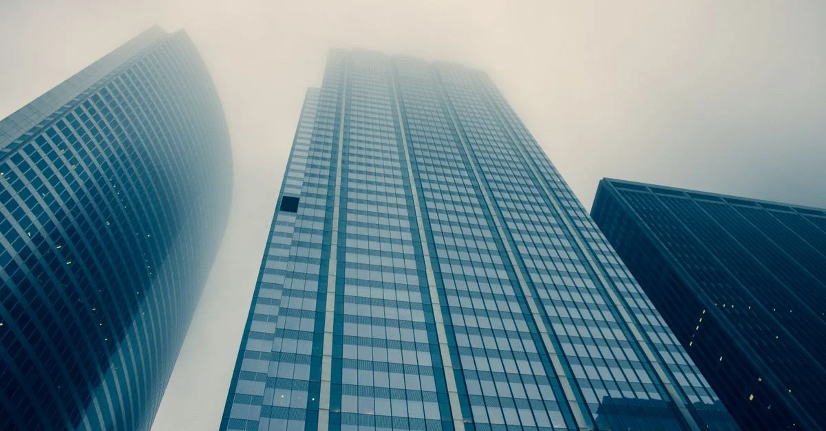 Vue captivante de gratte-ciels modernes atteignant des cieux brumeux, symbolisant la croissance urbaine.