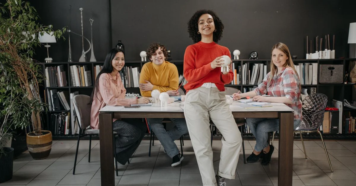 Quatre jeunes adultes divers collaborant dans un espace de travail moderne avec une décoration créative.