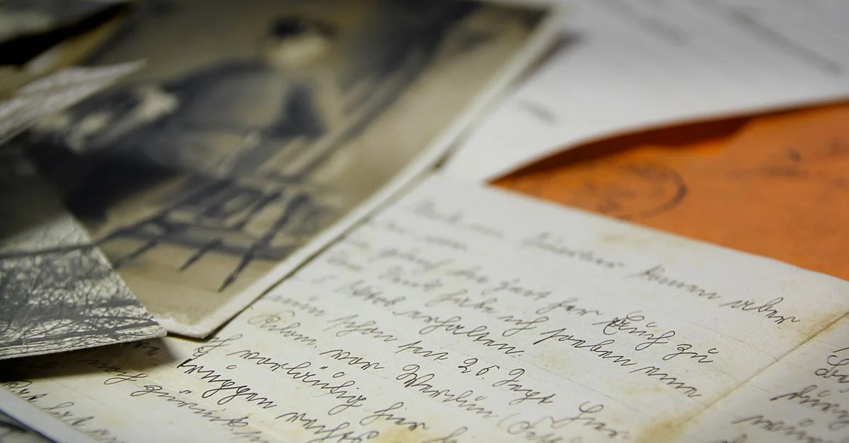 De vieilles lettres manuscrites et des photographies vintage étalées sur une table, créant une ambiance nostalgique.