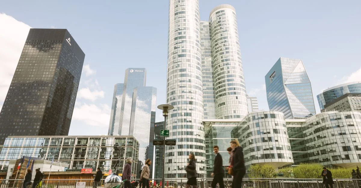 Scène dynamique des tours de La Défense avec des personnes marchant à Paris, France.