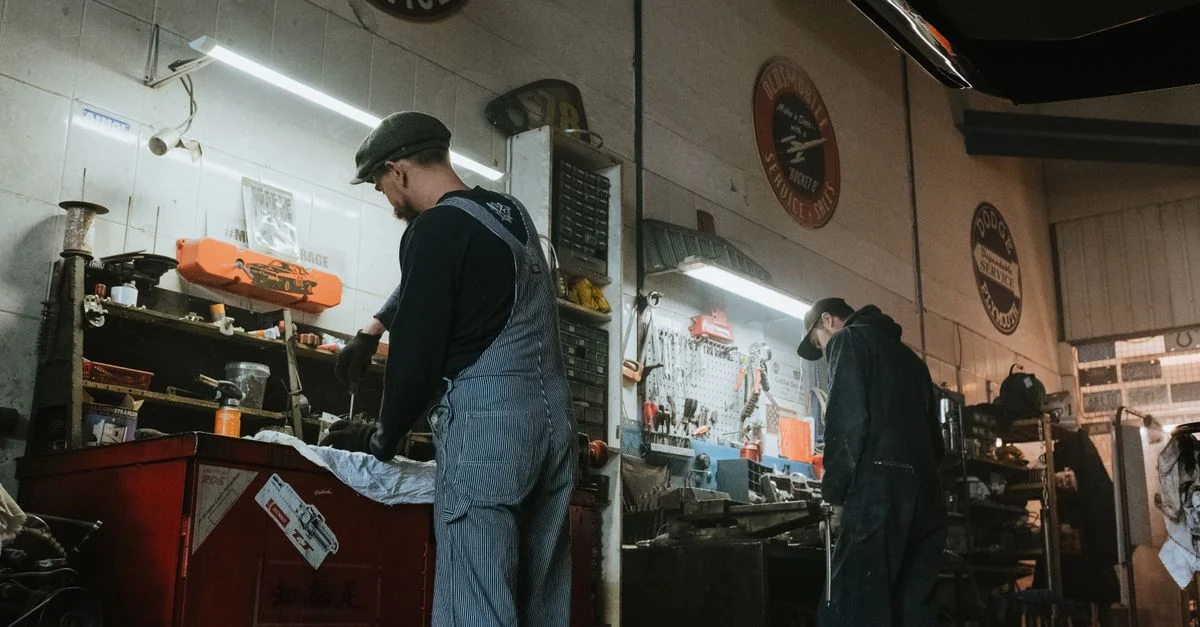 Deux mécaniciens dans un garage travaillant sur la réparation et l'entretien de véhicules.